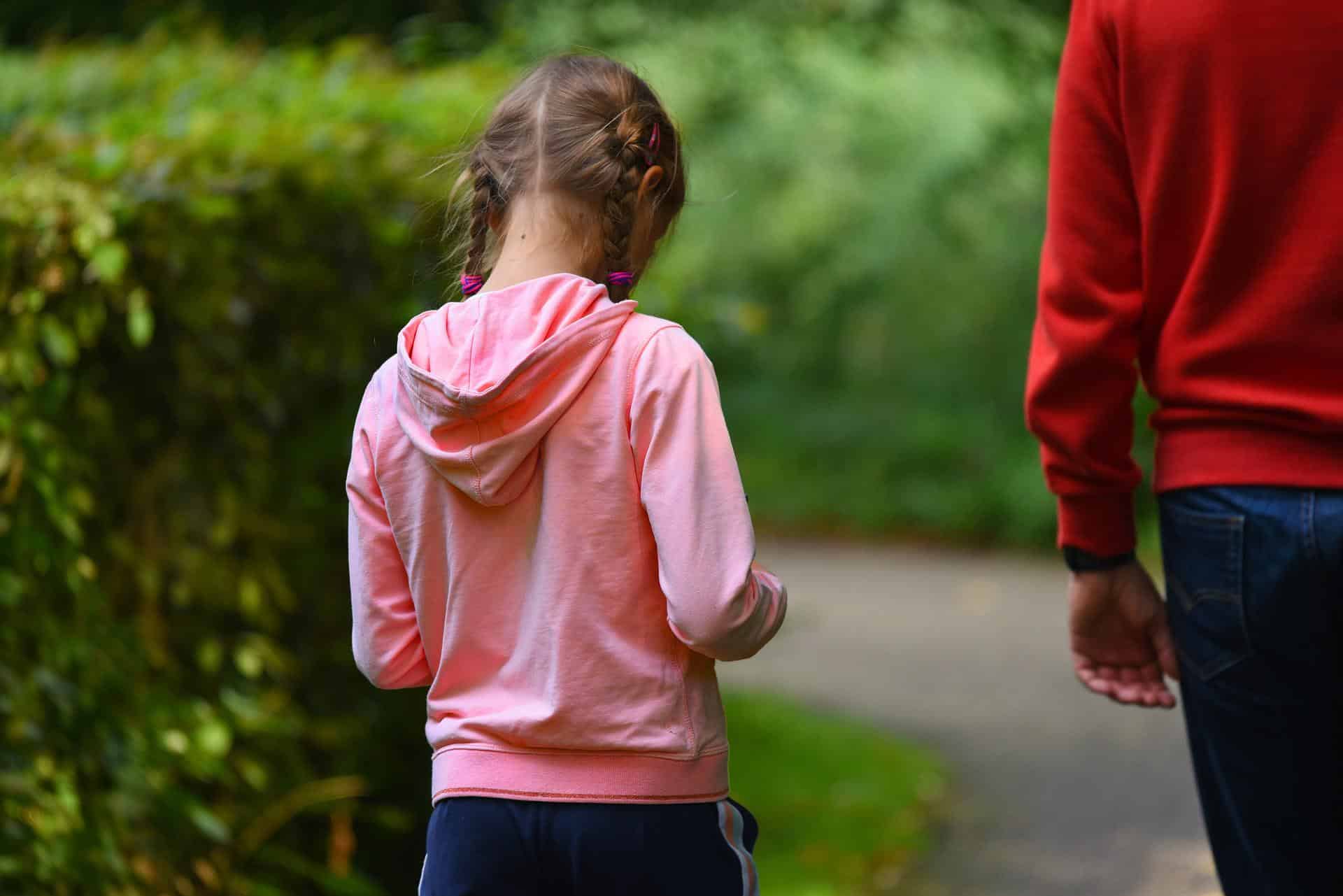 Sad child walking with parent
